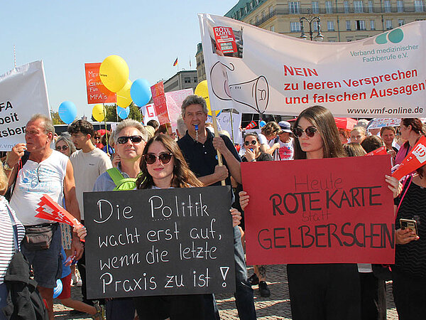 Teilnehmer der Protestveranstaltung der Medizinischen Fachangestellten in Berlin am 8. September 2023 halten Plakate in die Höhe.