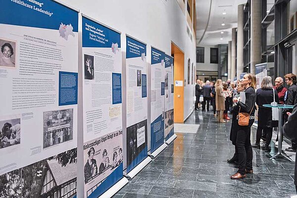 Besucher betrachten Informationstafeln bei der Wanderausstellung Systemerkrankung Arzt und Patient im Nationalsozialismus