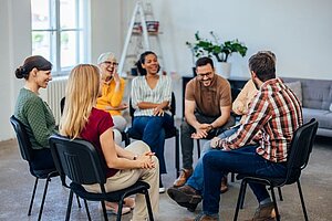 Menschengruppe sitzt in einer Gesprächsrunde zusammen