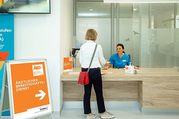 Empfangstresen der Bereitschaftspraxis Sigmaringen. Patientin stellt sich bei Anmeldung vor.